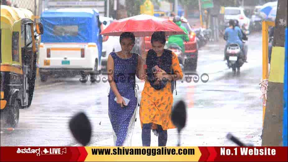 Two-Young-Ladies-walk-holding-umbreall-in-Rain